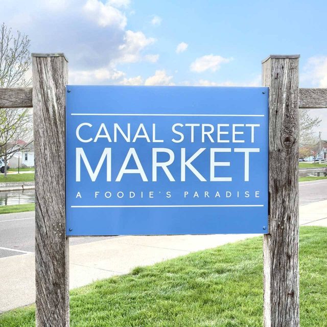 Blue Canal Street Market sign by the Winona Lake canals.