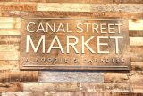 Wooden sign that says Canal Street Market A Foodie's Paradise