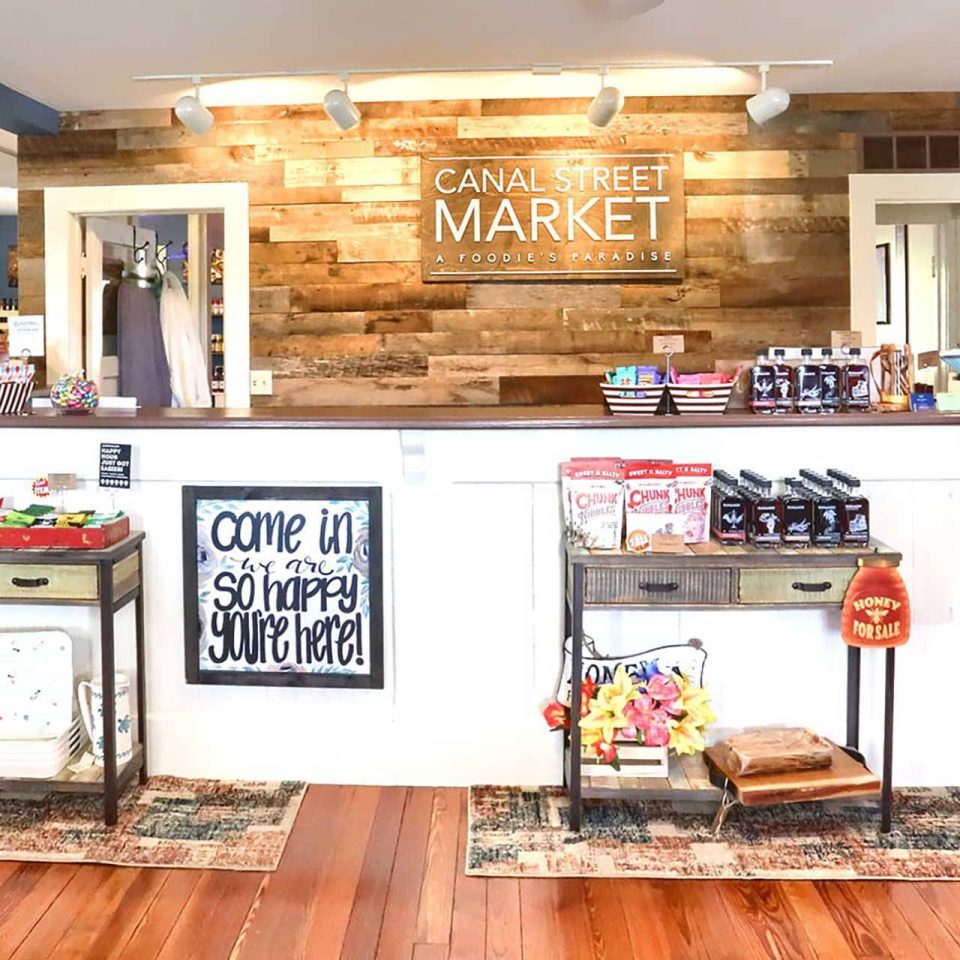 Interior Canal Street Market area at the front counter with food and decor items on display.