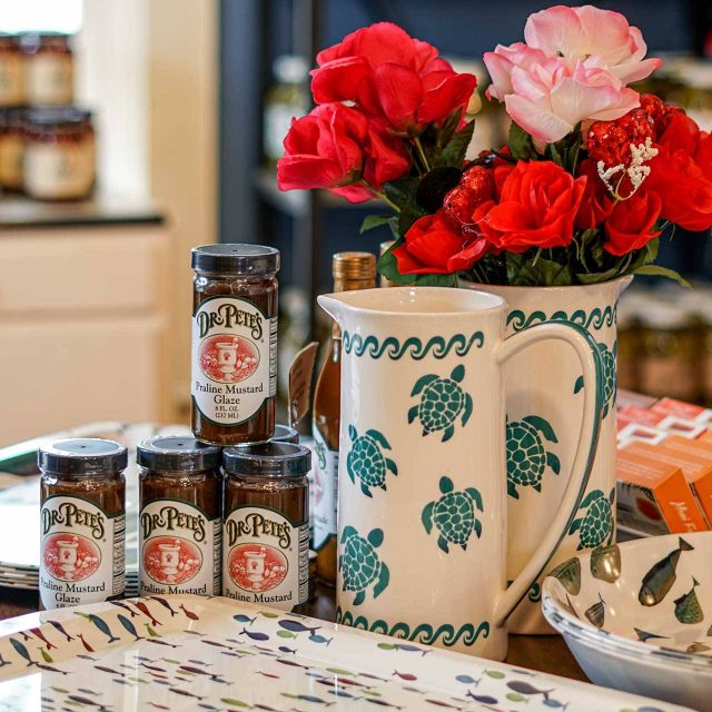 Table display at Canal Street Market with tabletop decor, trays, pitches, and Dr. Pete's praline mustard glaze.